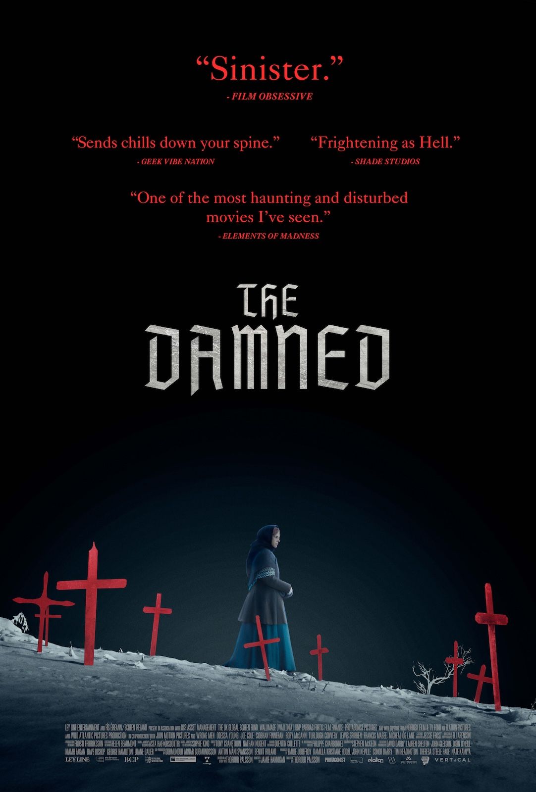 Text on poster: “The Damned.” Review quotes include “Sinister.” The image shows a lone figure walking through snow among red crosses.