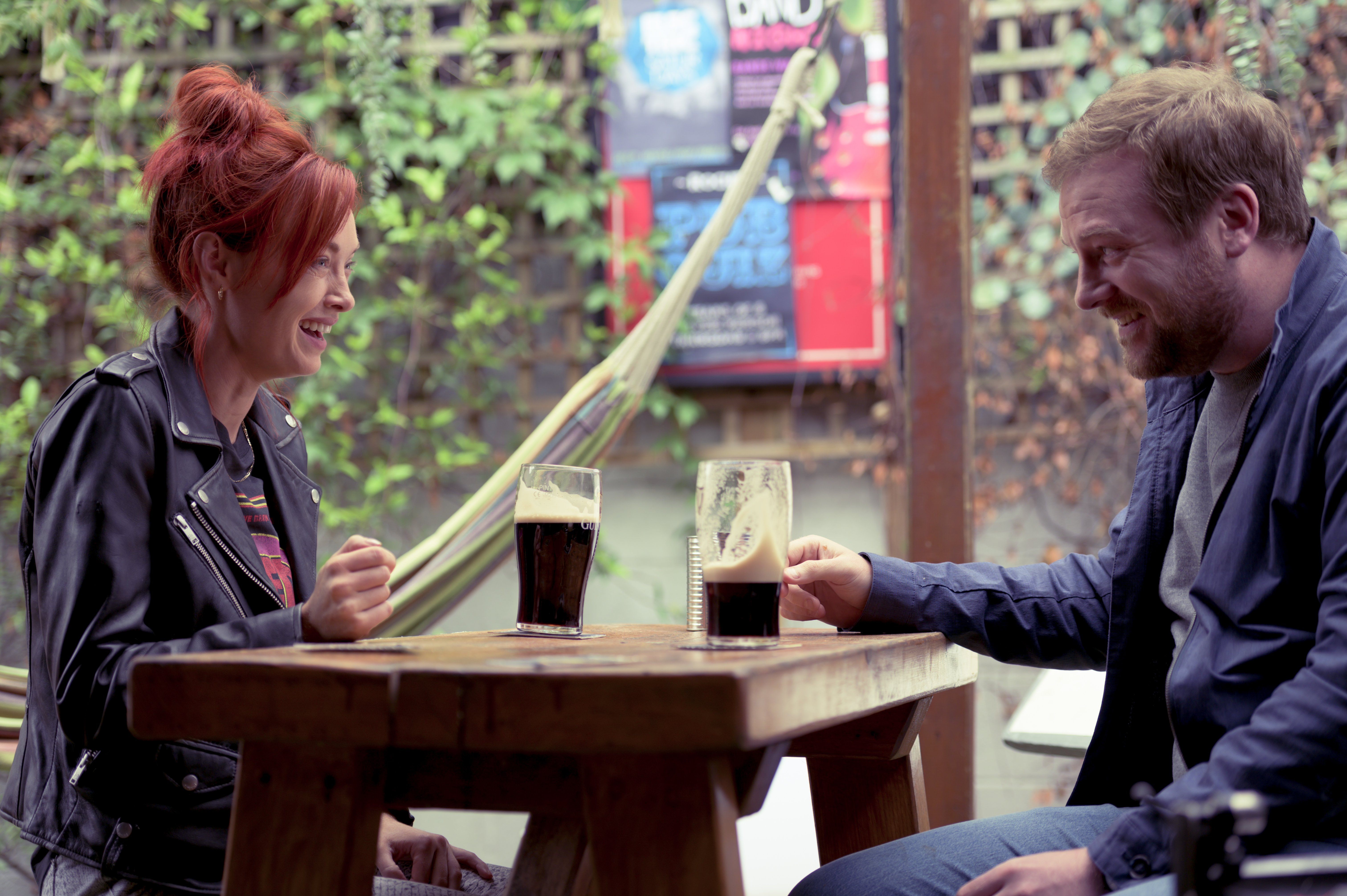Áine (Elva Trill) and Lloyd (Stephen Jones) sit together at a bar.